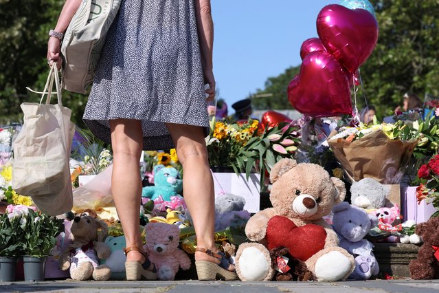 A woman looks at floral tributes and stuffed teddy bears in memory of Elsie Dot Stancombe, Bebe King and Alice Dasilva Aguiar, three children victims of a knife attack during a dance event in Southport, Britain on August 1, 2024. (Photo by Manon Cruz/Reuters)
