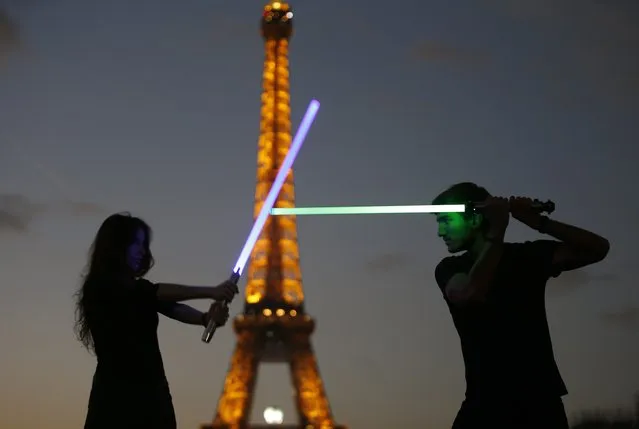 Marion (L) and Nikola (R), members of the Sport Saber League, pose with their light sabers in front of the Eiffel tower in Paris, France, November 26, 2015. Three "Star Wars" fans opened the French Academy of the Sport Saber League in September 2015 due to the increase interest for light saber fighting and the upcoming  movie "The Force Awakens" which will premier in Paris, December 16th, two days before its worldwide official release. (Photo by Charles Platiau/Reuters)