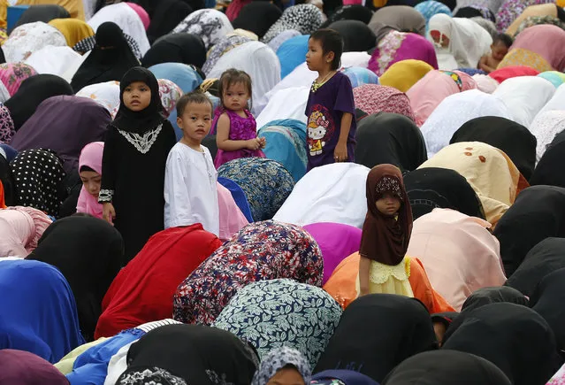 Children stand amidst Filipino Muslims praying to celebrate the end of the holy month of Ramadan known as Eid al-Fitr Friday, June 15, 2018 at the Blue Mosque in suburban Taguig city, east of Manila, Philippines. Muslims all over the world mark Eid al-Fitr with prayers, family reunions and gift-givings. (Photo by Bullit Marquez/AP Photo)
