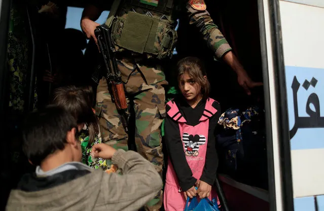 A girl who is fleeing the fighting between Islamic State and the Iraqi army in Mosul stands inside a bus at a Peshmerga checkpoint in Iraq November 14, 2016. (Photo by Zohra Bensemra/Reuters)