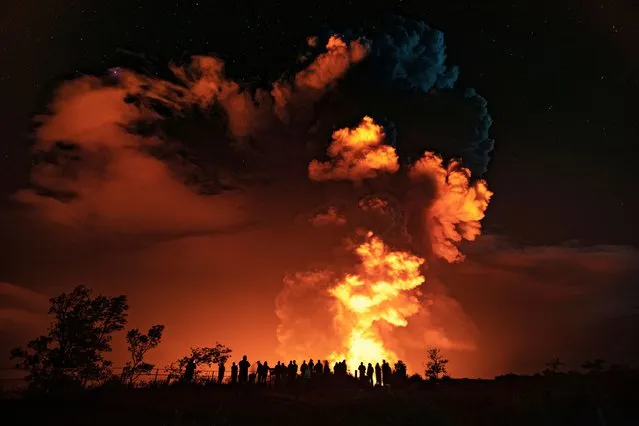 In this photo provided by the National Park Service, people watch an eruption from Hawaii's Kilauea volcano on the Big Island on Sunday, December 20, 2020. The volcano shot steam and an ash cloud into the atmosphere which lasted about an hour, an official with the National Weather Service said early Monday, Dec. 21, 2020. (Photo by Janice Wei/National Park Service via AP Photo)