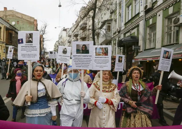 Activists dressed as women historical figures hold portraits of outstanding women in history at a rally on the occasion of the International Women's Day in Kyiv, Ukraine, Monday, March 8, 2021. Millions across the globe are marking International Women's Day by demanding a gender-balanced world amid persistent salary gap, violence and widespread inequality. (Photo by Efrem Lukatsky/AP Photo)