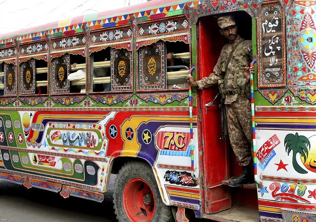 A Pakistani soldier stands guard in a bus carrying election staff and polling related material to stations in Karachi, Pakistan, Tuesday, July 24, 2018. As Pakistan prepares to make history Wednesday by electing a third straight civilian government, rights activists, analysts and candidates say the campaign has been among its dirtiest ever, imperiling the country's wobbly transition to democratic rule. (Photo by Shakil Adil/AP Photo)