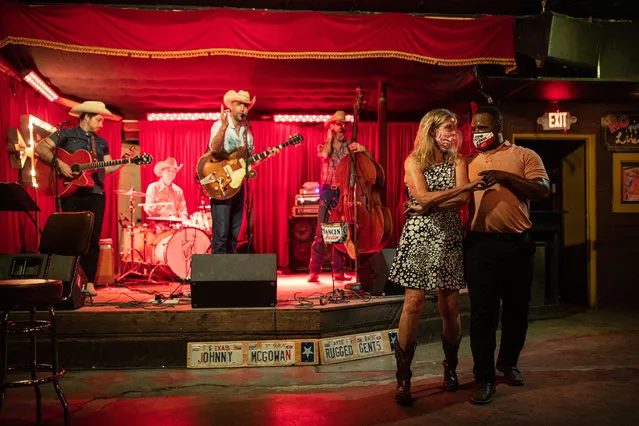 Lloyd Weatherspoon and Hope Wilson dance during a break between songs performed by Johnny McGowan's Rugged Gents at The White Horse on March 10, 2021 in Austin, Texas. The City of Austin said it will continue to maintain its mask rules despite an executive order from Gov. Greg Abbott, which took effect Wednesday, that lifted the statewide mask mandate and allowed businesses to fully reopen. (Photo by Tamir Kalifa/Getty Images)