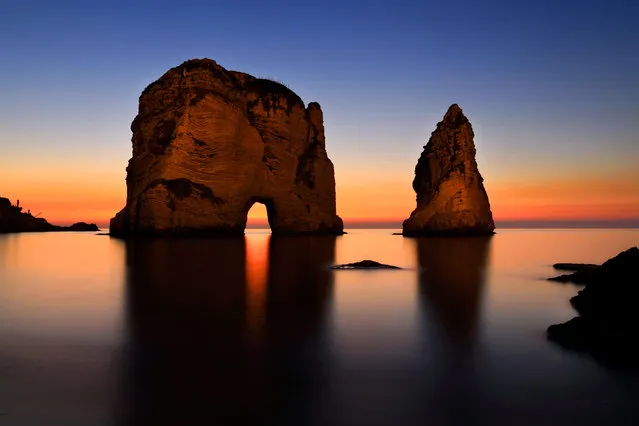 In this picture taken Wednesday, January 13, 2016 with a slow shutter speed, the sun sets over the Mediterranean Sea as seen at the Rawcheh Sea Rock in Beirut, Lebanon. (Photo by Hassan Ammar/AP Photo)