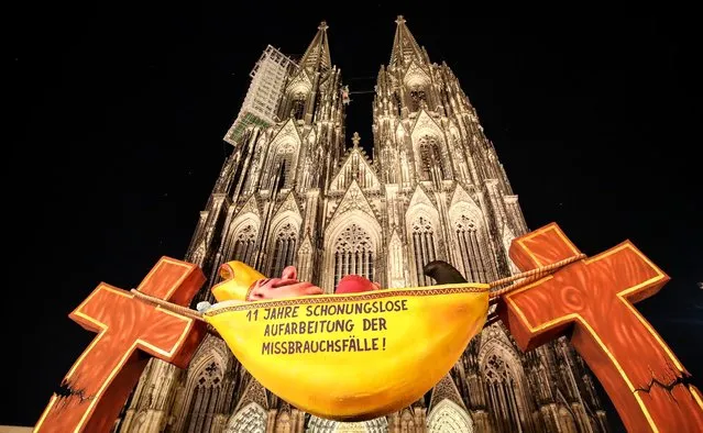 A sculpture by artist Jacques Tilly with the slogan “11 years of relentless reappraisal of the abuse cases!” is seen in front of the cathedral in Cologne, Germany, 17 March 2021. The new expert report on abuse and sexualised violence in the Archdiocese of Cologne will be presented on 18 March 2021. (Photo by Friedemann Vogel/EPA/EFE)