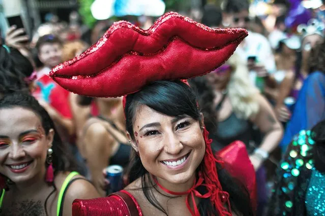 A Carnival reveler smiles at the camera during an unauthorized carnival block party called “blocos” in Rio de Janeiro, Brazil, Thursday, April 21, 2022. Some organizers couldn’t care less what Carnival events are authorized; they will turn out anyway – part party, part protest – and the mayor has said he will refrain from deploying the Municipal Guard. (Photo by Bruna Prado/AP Photo)