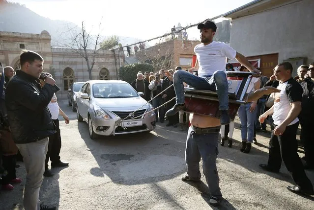 Etibar Elchiyev pulls two cars, attached to a home-made metal device that is magnetised to his body and carrying a man on it, in an attempt to set a new Guinness World Record for pulling a car by magnetism in Tbilisi, February 6, 2015. (Photo by David Mdzinarishvili/Reuters)