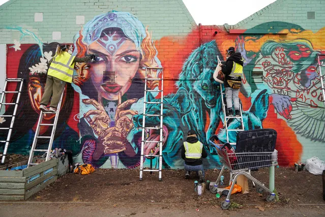 Members of the Wom Collective, a female street art collective, work on their new piece of street art in Brixton, south London, on March 7, 2021 to celebrate International Women's Day. (Photo by Niklas Halle'n/AFP Photo)