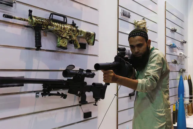 A visitor handles a gun during the International Defence Exhibition and Seminar “IDEAS 2016” in Karachi, Pakistan, November 24, 2016. (Photo by Akhtar Soomro/Reuters)