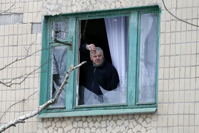 A man looks out of a window of a residential block damaged by a recent shelling in the town of Kramatorsk, eastern Ukraine February 10, 2015. (Photo by Gleb Garanich/Reuters)