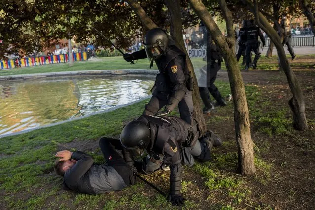 Spanish police detain a left-wing protester in Madrid's Vallecas neighborhood, Spain, Wednesday, April 7, 2021. Spanish police have used batons to keep protesters away from a campaign event of the far-right Vox party in Madrid. Scuffles started Wednesday when Santiago Abascal, the national leader of Vox, approached a crowd gathered to protest the party rally in Madrid's Vallecas neighborhood, a traditional left-wing bastion. Riot peace charged the bunches of protesters to keep them away from the party campaign event for upcoming regional elections. (Photo by Bernat Armangue/AP Photo)