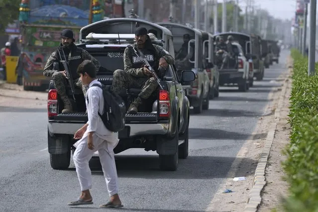 A conv0y of paramilitary forces and police patrol on a road after an angry Muslim mob attacked a Christian area in Jaranwala in the Faisalabad district, Pakistan, Thursday, August 17, 2023. (Photo by K.M. Chaudary/AP Photo)