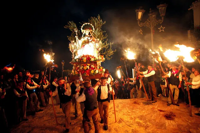 Villagers carry a statue of the Virgin of Los Rondeles during the Divina Pastora procession, as part of a festival to honour the Virgin of Los Rondeles, in the southern Spanish village of Casarabonela, near Malaga, late December 12, 2016. (Photo by Jon Nazca/Reuters)