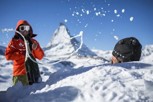 Reto Gilli (R), manager of the Igloo-village in Zermatt, is getting showered with champagne before piling one of the last snow bricks during the builing work for the world record attempt for the largest classic igloo with a diameter of 13 meters and a ceiling hight of 11 meters in Zermatt, Switzerland, 21 January 2016. This world record attempt is hold during the 20th anniversary of the Igloo-village on an altitude of 2,727 meters. A total of 1,700 snow bricks are needed during the construction phase of two weeks. By now, the largest Igloo was built on 19 February 2011 in Grand Falls, Canada with a diameter of 9,2 meters and a ceiling hight of 5,3 meters. (Photo by Dominic Steinmann/EPA)