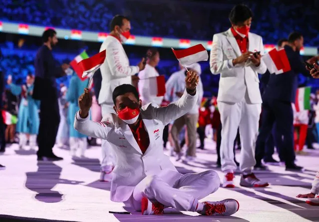 Member of Indonesia's delegation sit on the floor during Tokyo 2020 Olympic Games opening ceremony's parade of athletes, at the Olympic Stadium in Tokyo on July 23, 2021. (Photo by Stefan Wermuth/Reuters)