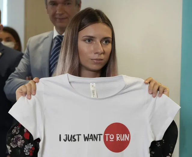 Belarusian Olympic sprinter Krystsina Tsimanouskaya, who came to Poland Wednesday fearing reprisals at home after criticizing her coaches at the Tokyo Games, is showing an Olympic-related T-shirt with her slogan “I Just Want to Run” after her news conference in Warsaw, Poland, on Thursday, August 5, 2021. Tsimanouskaya reached Poland by plane from Tokyo through Vienna, a circuitous route due to security concerns, days after she accused team officials of trying to force her to fly back to Belarus, where an authoritarian government has relentlessly pursued its critics. (Photo by Czarek Sokolowski/AP Photo)