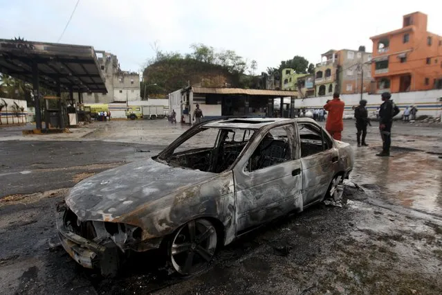 The wreckage of a burnt out vehicle is pictured after explosions at an LPG gas distribution station in Santo Domingo, Dominican Republic, February 16, 2016. At least 40 people were injured and the cause of the explosions is still being investigated, according to rescue services. (Photo by Ricardo Rojas/Reuters)