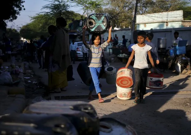 Residents carry empty containers to fill water from a municipal tanker in New Delhi, India, February 21, 2016. (Photo by Anindito Mukherjee/Reuters)