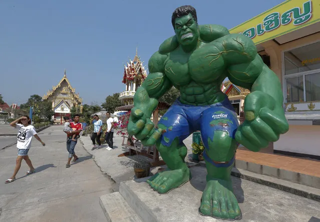 People walk past a statue of comic character the Hulk at Tamru temple in Samut Prakan province, Thailand, March 3, 2016. The temple said it had set up statues of Hollywood and comic characters to attract more people to visit the temple. (Photo by Chaiwat Subprasom/Reuters)