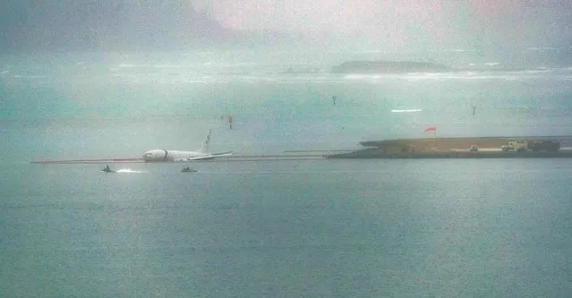 A military aircraft is seen in the shallow waters of Kaneohe Bay after skidding off the end of the runway at Marine Corps Hawaii in Kaneohe on November 20, 2023. The aircraft is a Boeing P8 Poseidon, described as a military surveillance and patrol aircraft. According to the Hawaiian press, the crew of nine was on board. The condition of the crew is not known. (Photo by Eugene Tanner/AFP Photo)