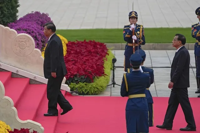Chinese President Xi Jinping, left, and Premier Li Keqiang walk past a guard of honor while visiting the Monument to the People's Heroes during a ceremony to mark Martyr's Day at Tiananmen Square in Beijing, Thursday, September 30, 2021. (Photo by Andy Wong/AP Photo)
