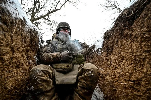 A Ukrainian serviceman smokes at a position near a front line, in Zaporizhzhia region, Ukraine on January 14, 2024. (Photo by Reuters/Stringer)