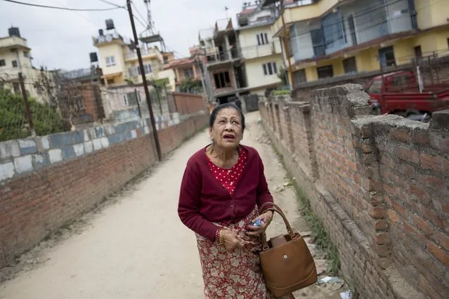 An elderly Nepalese woman reacts during an aftershock, in Kathmandu, Nepal, Sunday, April 26, 2015. (Photo by Bernat Armangue/AP Photo)