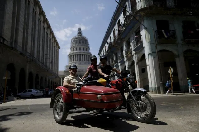 Tourists ride in a vintage motorcycle with a sidecar in downtown Havana, March 16, 2016. (Photo by Ueslei Marcelino/Reuters)
