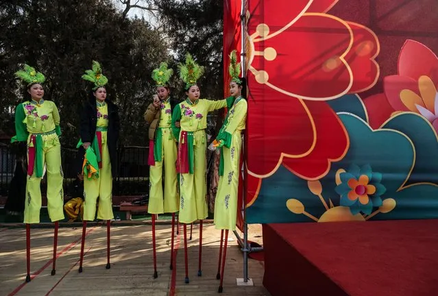 Members of a folk dancing troupe that perform on stilts, or gaoqiao, wait to perform at a local temple fair for the Chinese Lunar New Year and Spring Festival on February 13, 2024 in Beijing, China. China ushered in the Year of the Dragon and the Lunar New Year and Spring Festival on February 10th. (Photo by Kevin Frayer/Getty Images)