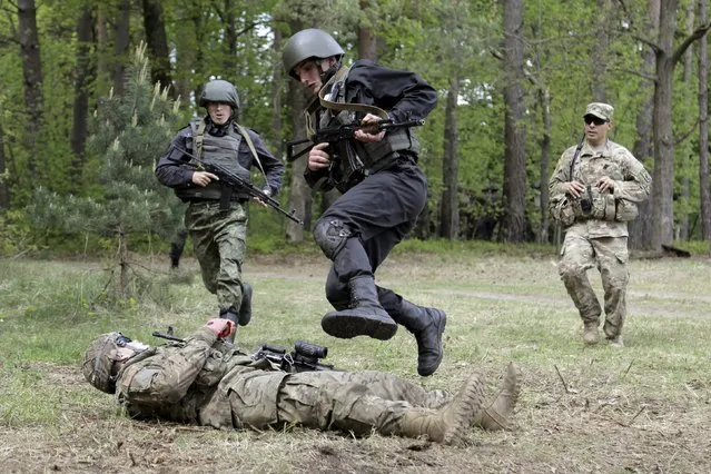 Servicemen of the U.S. Army's 173rd Airborne Brigade Combat Team (bottom and R) train members of the Ukrainian National Guard during a joint military exercise called “Fearless Guardian 2015” at the International Peacekeeping and Security Center near the western village of Starychy, Ukraine, May 7, 2015. (Photo by Roman Baluk/Reuters)