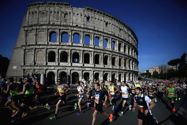 Competitors run by the Colosseum, during the Rome Marathon in Rome, on March 17, 2024. (Photo by Filippo Monteforte/AFP Photo)