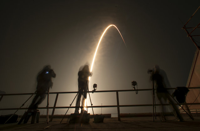 Photographers follow a SpaceX Falcon 9 rocket during a time exposure as it lifts off from Launch Complex 39A at the Kennedy Space Center in Cape Canaveral, Fla., Thursday, December 9, 2021. The Falcon 9 will deploy into orbit NASA's Imaging X-ray Polarimetry Explorer (IXPE) spacecraft, an X-ray astronomy mission to study black holes and neutron stars. (Photo by John Raoux/AP Photo)