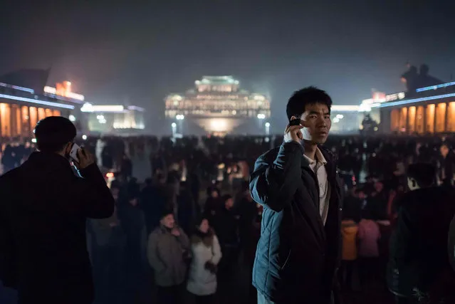 A man talks on a mobile phone after a fireworks display in front of Kim Il-Sung square, and next to an ice festival near the Taedong river, on the occasion of the 75th anniversary of the birth of Kim Jong-Il, in central Pyongyang on February 16, 2017. (Photo by Ed Jones/AFP Photo)