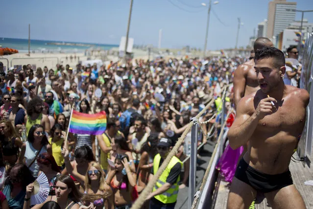A man dances during the annual Gay Pride Parade in Tel Aviv, Israel, Friday, June 12, 2015. Thousands of bare-chested muscular men, drag queens in heavy makeup and high heels, women in colorful balloon costumes and others partied at Tel Aviv's annual gay pride parade on Friday, the largest event of its kind in the region. (AP Photo/Ariel Schalit)
