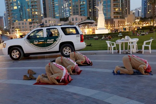 Members of the Emirates police pray after breaking their fast outside the Dubai mall during the holy month of Ramadan in Dubai, United Arab Emirates, April 23, 2021. (Photo by Rula Rouhana/Reuters)