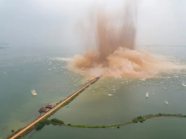 A dike between two lakes is seen under demolition in Wuhan, Hubei Province, China, July 14, 2016. (Photo by Reuters/China Daily)