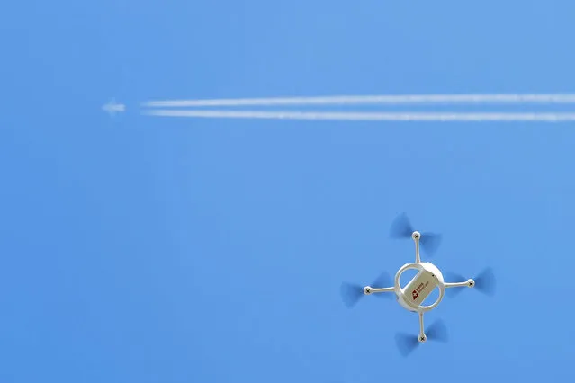 A drone of the Swiss Post with a small parcel flies in Bas-Vully, Switzerland, 07 July 2015. Swiss Post presents and tests a drone that could be used to deliver urgently needed goods to hard-to-reach places. Swiss Post, Swiss WorldCargo (the airfreight division of Swiss) and Matternet (drone manufacturer in California) have launched a joint project to test the use of drones for package delivery. (Photo by Jean-Christophe Bott/EPA)