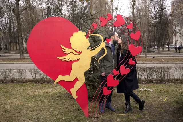 Anna Panasyk and Dmytro Shybalov pose by a heart shaped installation outside a marriage office before getting married in Kyiv, Ukraine, Friday, March 4, 2022. A Russian attack at Europe's biggest nuclear power plant in Ukraine did not result in any radiation being released and firefighters extinguished a blaze at the facility, U.N. and Ukrainian officials said, as Russian forces pressed their campaign Friday to cripple the country despite global condemnation. (Photo by Vadim Ghirda/AP Photo)