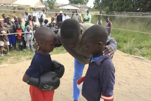 In this Sunday, March 11, 2017 photo, a referee gives children instructions before they fight, in a boxing ring in Chitungwiza. (Photo by Tsvangirayi Mukwazhi/AP Photo)