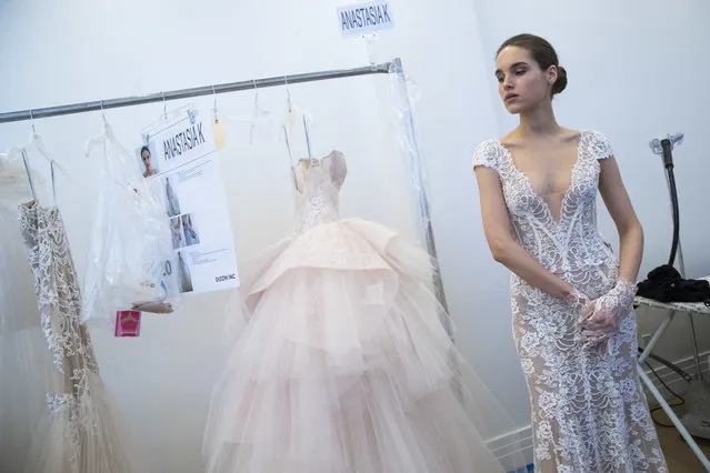 In this Friday, April 21, 2017 photo, a model is seen backstage ahead of the Monique Lhuillier bridal collection presentation during bridal fashion week in New York. (Photo by Mary Altaffer/AP Photo)