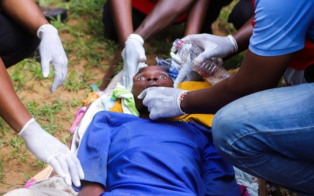 Members of the Kenya Red Cross attend to an emaciated member of a Christian cult named “Good News International Church”, whose members believed they would go to heaven if they starved themselves to death, in the Shakahola forest of Kilifi county, Kenya on April 23, 2023. (Photo by Reuters/Stringer)