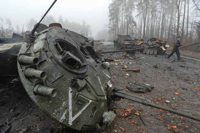 A Ukrainian service member walks next to destroyed Russian military vehicles, as Russia's attack on Ukraine continues, in the village of Dmytrivka in Kyiv region, Ukraine on April 1, 2022. (Photo by Oleksandr Klymenko/Reuters)