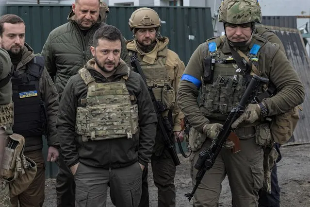 Ukraine's President Volodymyr Zelenskiy looks on as he is surrounded by Ukrainian servicemen as Russia's invasion of Ukraine continues, in Bucha, outside Kyiv, Ukraine, April 4, 2022. (Photo by Marko Djurica/Reuters)