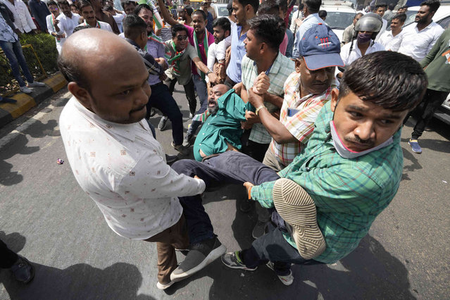 Policemen in civilian clothes detain a supporter of India's main opposition Congress party during a protest against price rise in Ahmedabad, India, Friday, April 1, 2022. (Photo by Ajit Solanki/AP Photo)