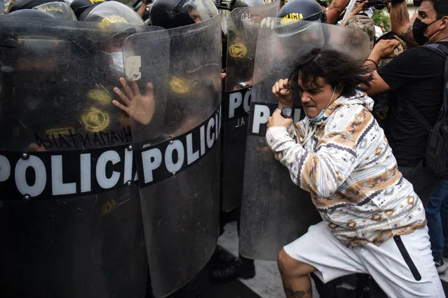People clash with riot police during a protest against the governement of Peru's President Pedro Castillo, in Lima on April 05, 2022. Peruvian President Pedro Castillo announced the end of a curfew in the capital Lima aimed at containing protests against rising fuel prices following crisis talks with Congress. (Photo by Ernesto Benavides/AFP Photo)