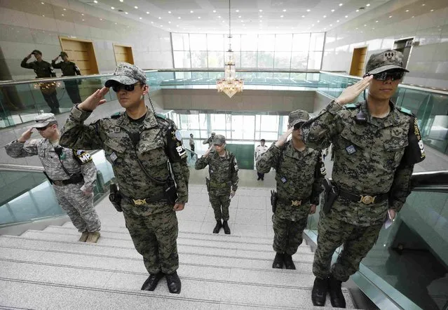 South Korean army soldiers salute during a ceremony to commemorate the 62nd anniversary of the Korean War Armistice Agreement that ended the Korean War at the border village of Panmunjom, which has separated the two Koreas since the Korean War in Paju, South Korea, July 27, 2015. (Photo by Ahn Young-joon/Reuters)