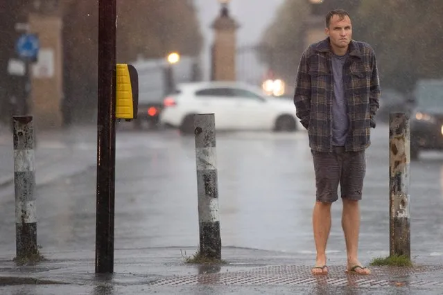 A man wears flip flops as he waits at a set of traffic lights outside Greenwich Park in South East London, United Kingdom on October 2, 2021. (Photo by London News Pictures)