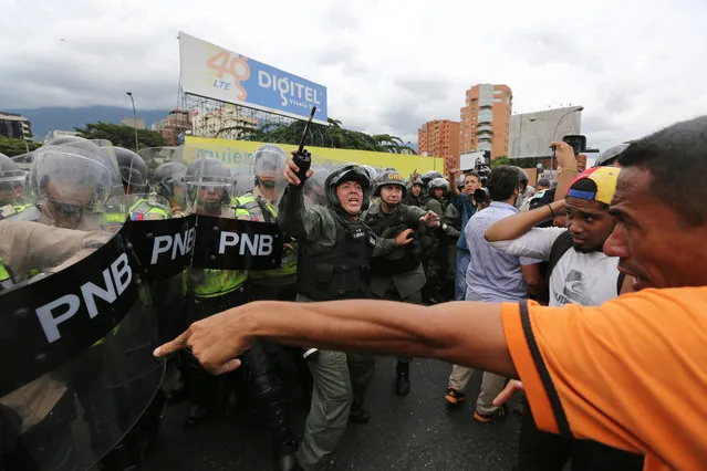 Opposition protesters argue with Bolivarian National Police blocking their path on the Francisco Fajando highway in Caracas, Venezuela, Tuesday, June 7, 2016. Protesters were turned back from the headquarters of Venezuela's electoral body where the group attempted to march to demand the government allow it to pursue a recall referendum against President Nicolas Maduro. (Photo by Fernando Llano/AP Photo)