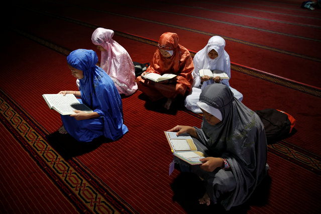 A group of youths read Koran as they wait to break the fast during the holy month of Ramadan inside Istiqlal mosque in Jakarta, Indonesia June 9, 2016. (Photo by Reuters/Beawiharta)